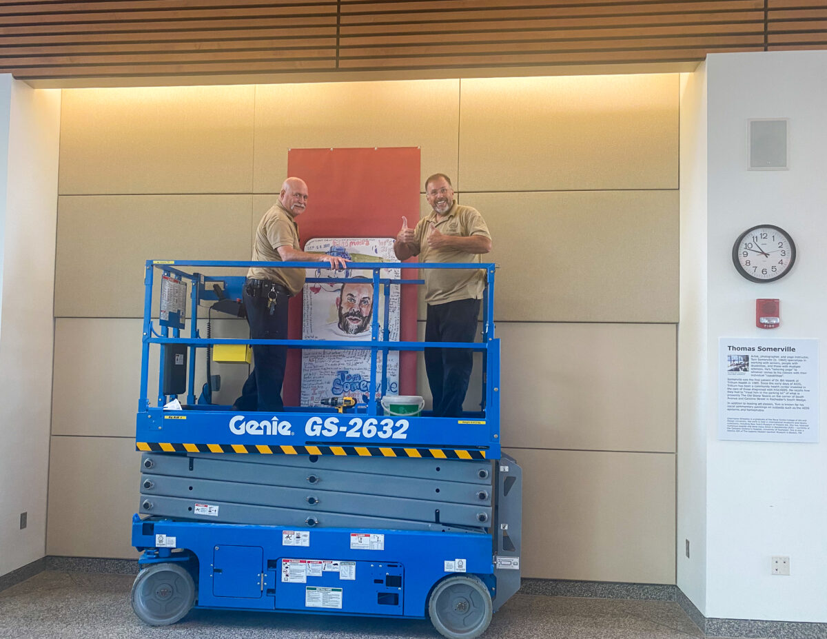 facilities staff putting up a banner